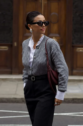 a lady wears a grey cardigan with black pants
